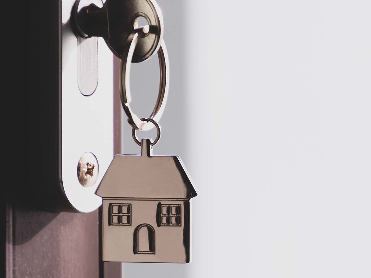 Renter's keychain with house icon inserted into house lock